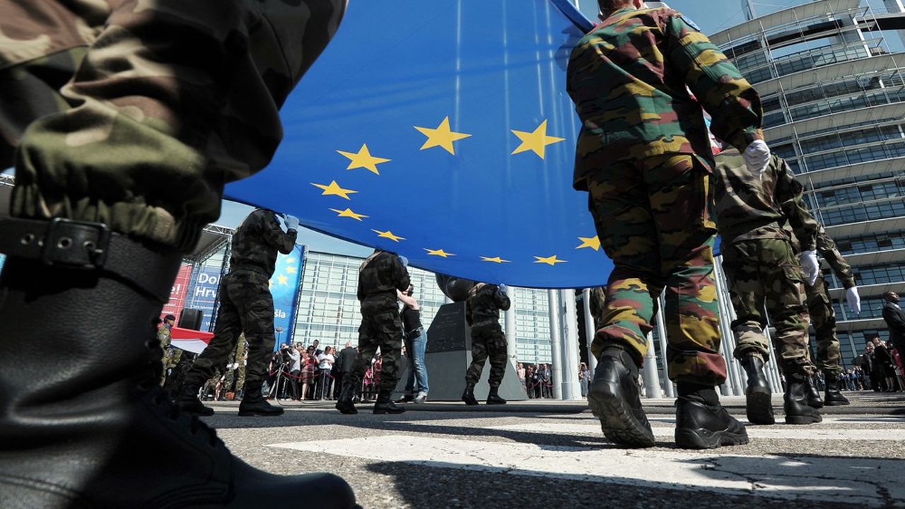 Des membres du contingent militaire de l'Eurocorps tenant le drapeau européen.