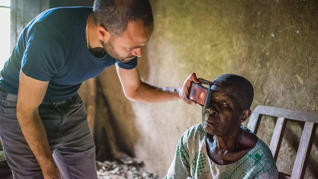 Le lauréat Andrew Bastawrous examine les yeux d’une Kényane avec son application Peek.