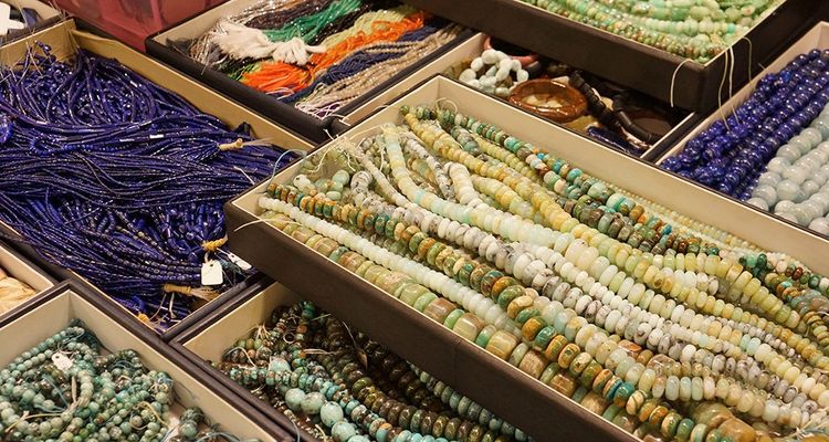 Rangs de lapis lazuli et de billes de turquoises enfilées sur des fils de coton.