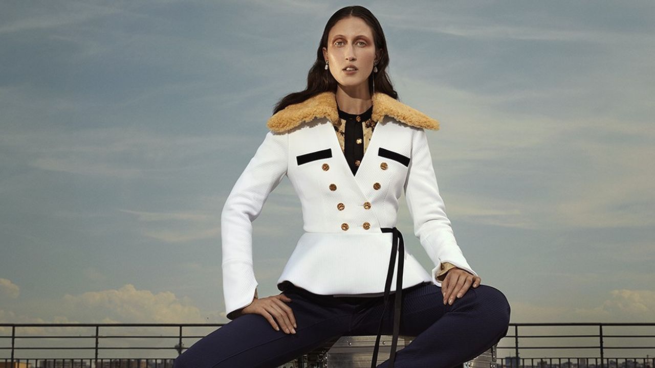 Anna Cleveland porte des boucles d'oreilles, veste, body , pantalon et escarpins Louis Vuitton.