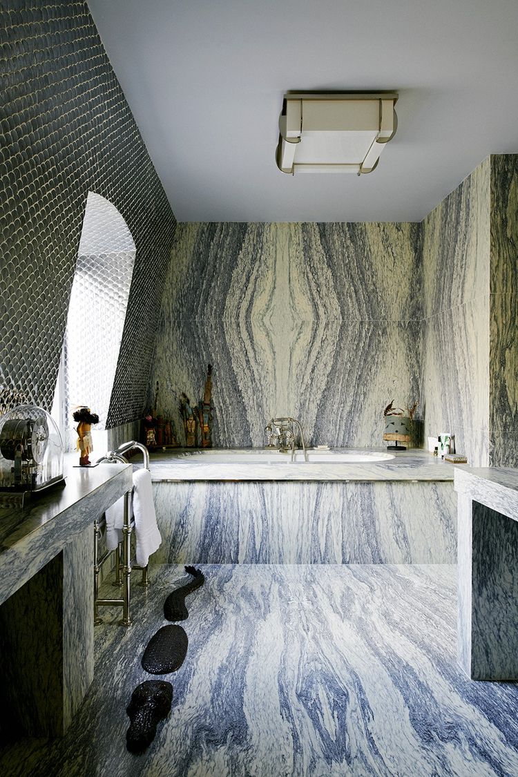 Tapissée de marbre et éclairée d'une suspension Perzel des années 30, la salle de bains est une évocation du palais du maharajah d'Indore