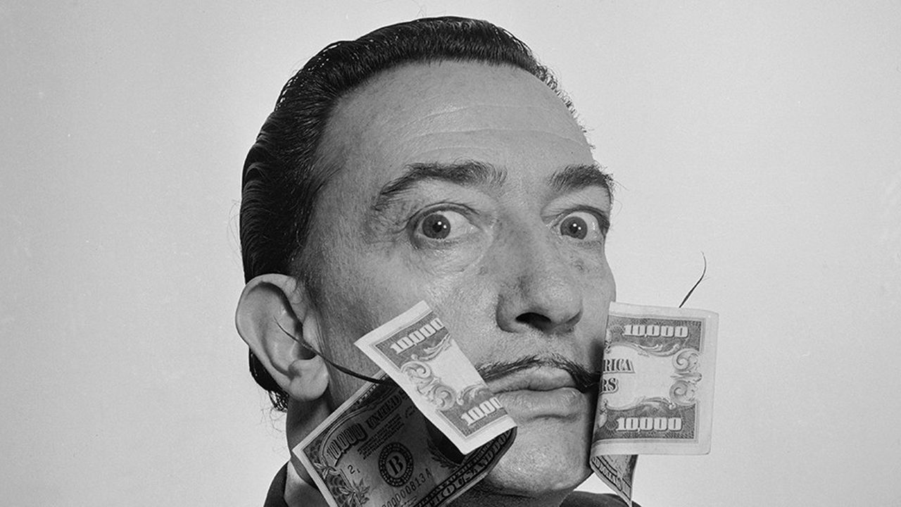 Salvador Dali posant avec, de part et d'autre de sa moustache si caractéristique, deux billets de 10.000 $., 1954