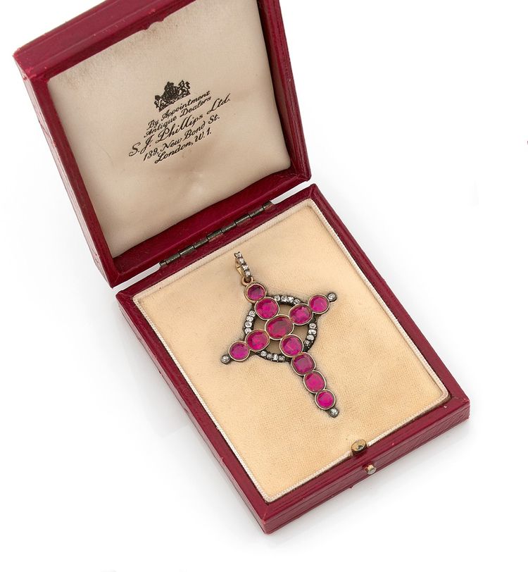 Croix-pendentif en or jaune 18K (750) et argent ornée deonze rubis ovales, enrichie d'une orbe sertie de diamants de taillesanciennes.