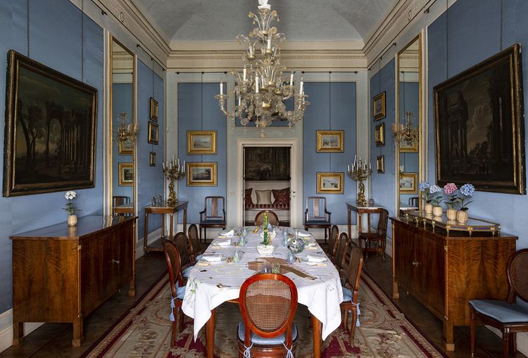 La salle à manger a des proportions palatiales. Son élégante rigueur est adoucie par les fleurs en porcelaine de Samuel Mazy et par une nappe brodée à Florence.
