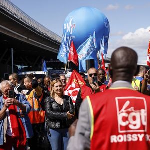 Des grévistes de la CGT manifestent devant un terminal, vendredi 1er juillet 2022, à l'aéroport de Roissy, au nord de Paris.