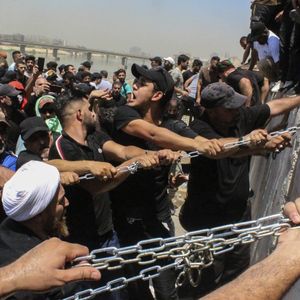 Des manifestants tentent de retirer des barrières pour traverser le pont qui mène à la Zone verte de Bagdad, samedi dernier.