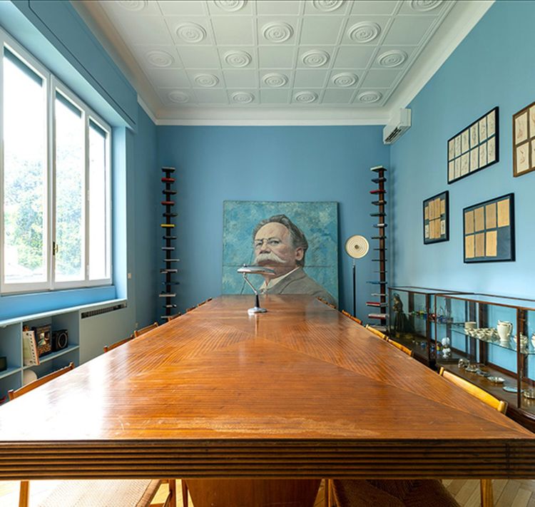 Dans la salle à manger, une grande table dénichée à Milan et les chaises «Superleggera» de Gio Ponti trônent sous le regard d'un leader communiste italien.