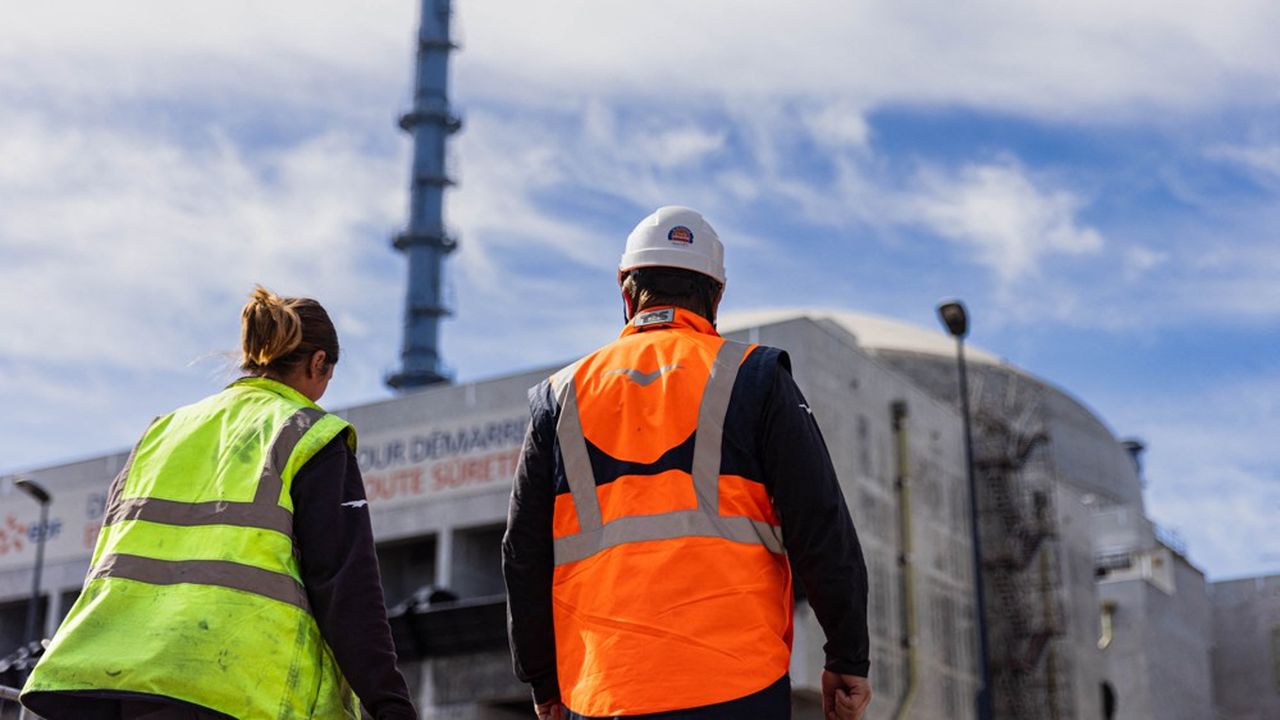 Des employés passent devant le bâtiment d'un réacteur sur le site de l'EPR de Flamanville, en Normandie, le 14 juin 2022. L'EPR doit être mis en service en 2023 après de nombreux retards. (Sameer Al-DOUMY/AFP)