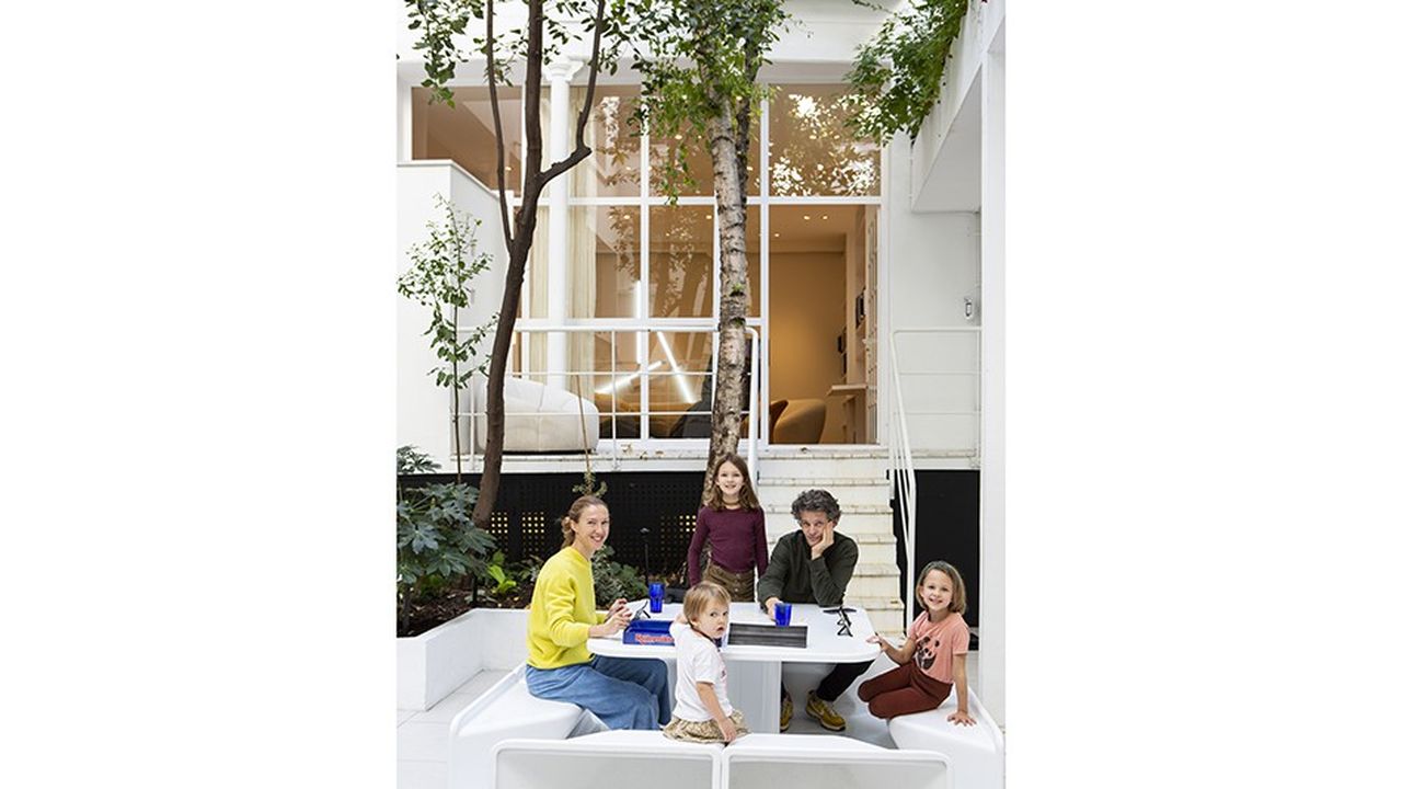 Alice et Benjamin Paulin avec leurs enfants, dans la cour de leur domicile parisien, autour de la table «Miami» éditée pour l'exposition organisée par Louis Vuitton en 2014 à Miami.