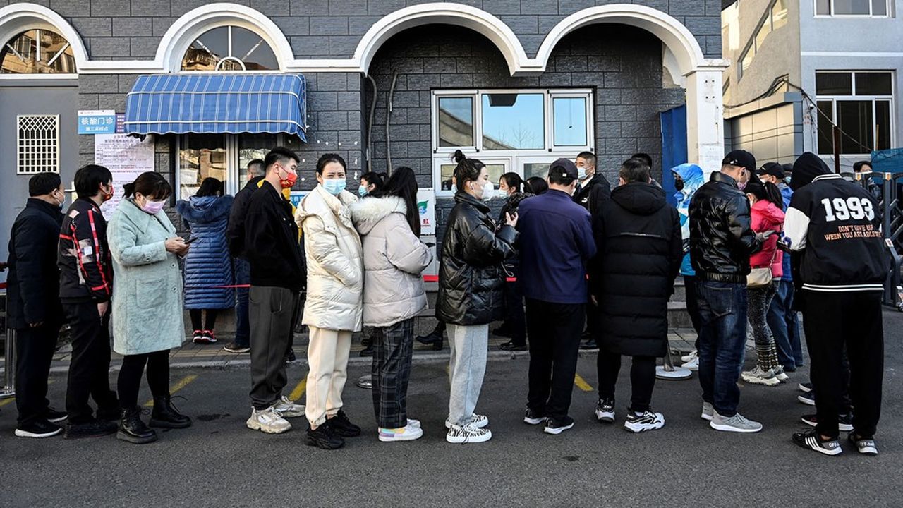 Des Pékinois font la queue pour se faire tester pour le Covid devant un hôpital.