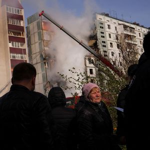 Des personnes se tiennent devant un immeuble résidentiel lourdement endommagé par un missile russe, à Uman, ce vendredi 28 avril 2023.