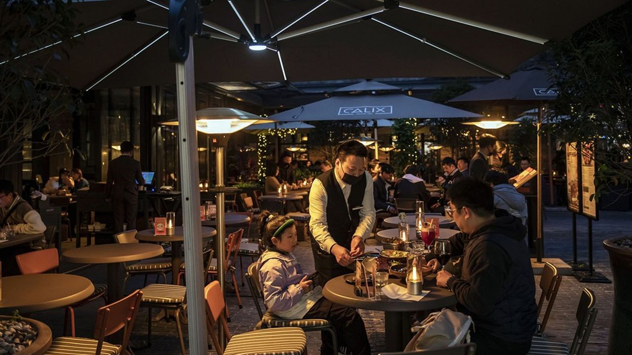 Des consommateurs attablés à une terrasse de café à Shanghai.