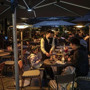 Des consommateurs attablés à une terrasse de café à Shanghai.