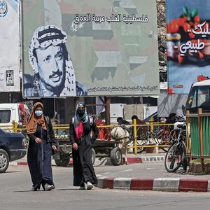 Des habitants de la bande de Gaza passent devant le portrait du leader palestinien, Yasser Arafat, près de vingt ans après sa mort.