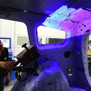 Une technicienne d'A2Mac1 numérise l'intérieur d'un véhicule à l'aide d'un laser.