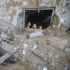 Des enfants palestiniens contemplent les destructions de leur quartier, dans la bande de Gaza, après des raids israéliens.