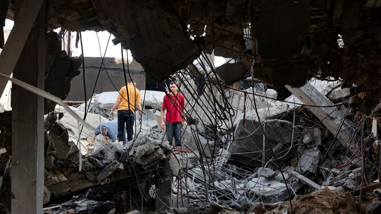 Palestiniens dans des décombres après des frappes israéliennes sur le camp d'Al-Shatee dans la ville de Gaza le 28 octobre 2023.