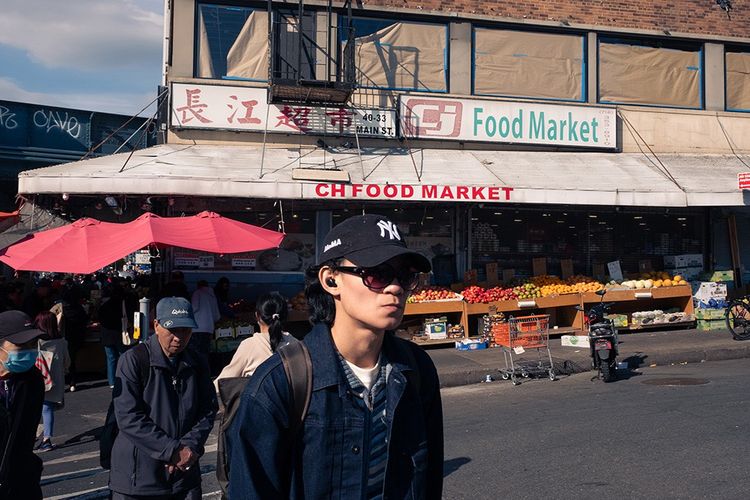 Queens, New York. Des passants devant un supermarché chinois dans le quartier Flushing. 