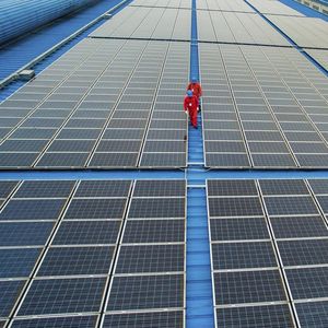 Des ouvriers examinent des panneaux photovoltaïques dans la province du Zhejiang (est de la Chine).