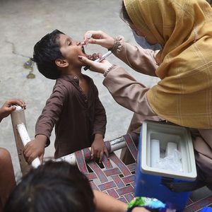 Une professionnelle de santé administre le vaccin contre la polio à un enfant à Karachi (Pakistan).