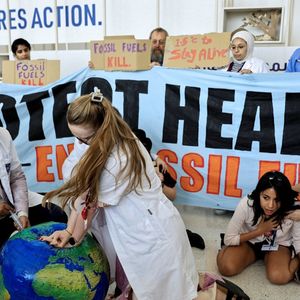 Des membres de la Fédération internationale des associations d'étudiants en médecine demandent la fin des énergies fossiles dans le monde, lors d'une action symbolique à la COP28, à Dubaï.