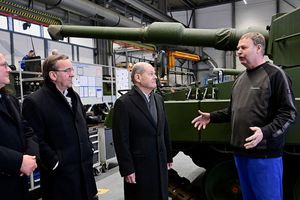 De gauche à droite, le patron de Rheinmetall, Armin Papperger, le ministre de la Défense, Boris Pistorius, et le chancelier allemand, Olaf Scholz, échangent avec un employé d'une usine Rheinmetall d'Unterlüss, en Basse-Saxe.