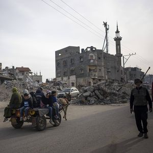 Des Palestiniens longent les bâtiments détruits par une frappe aérienne israélienne à Rafah, dans la bande de Gaza, le 23 février 2024.
