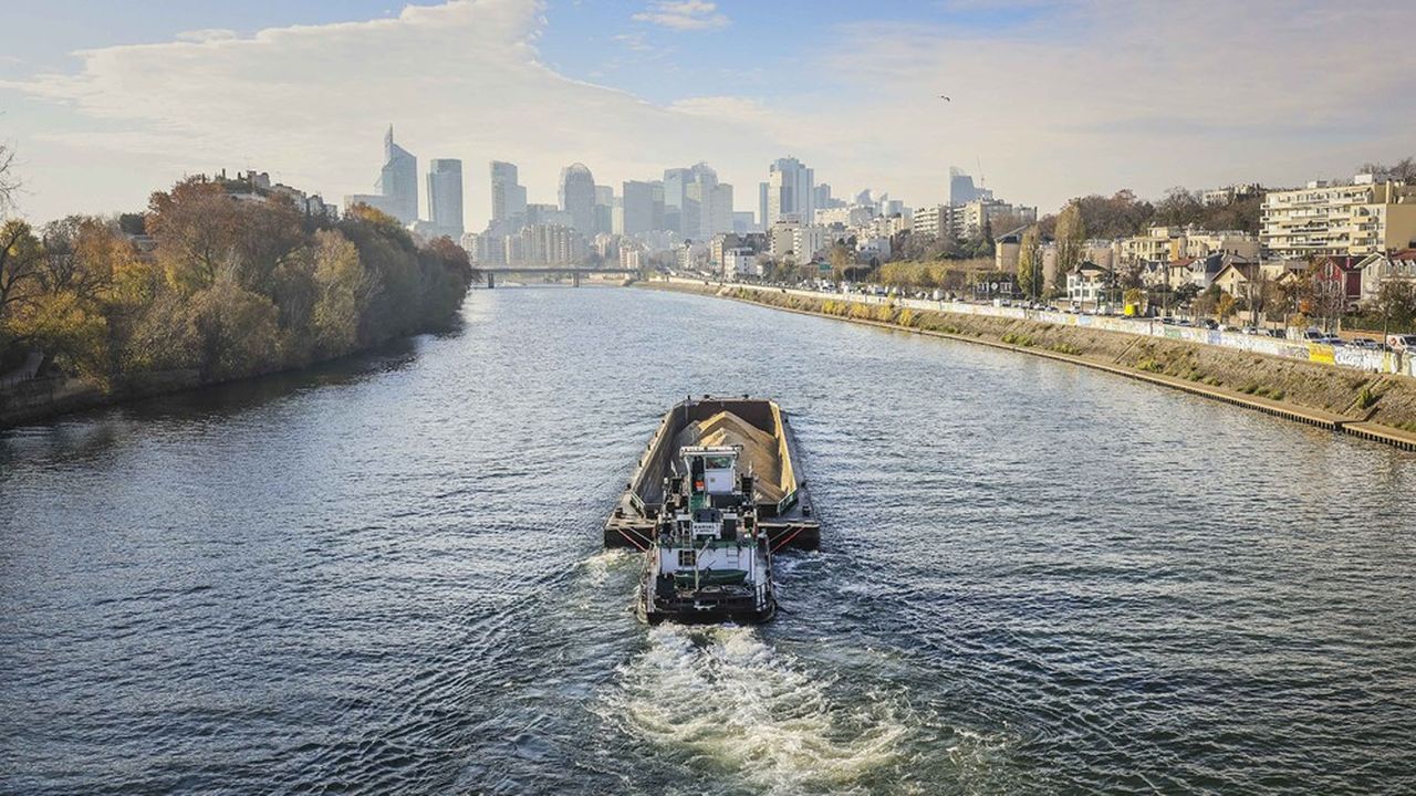 Une péniche naviguant sur la Seine avec des graviers. Le secteur du transport fluvial a subi l'impact des difficultés du BTP.