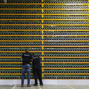 Deux techniciens inspectent le mineur de bitcoins de Bitfarms à Saint-Hyacinthe, au Québec, le 19 mars 2018.