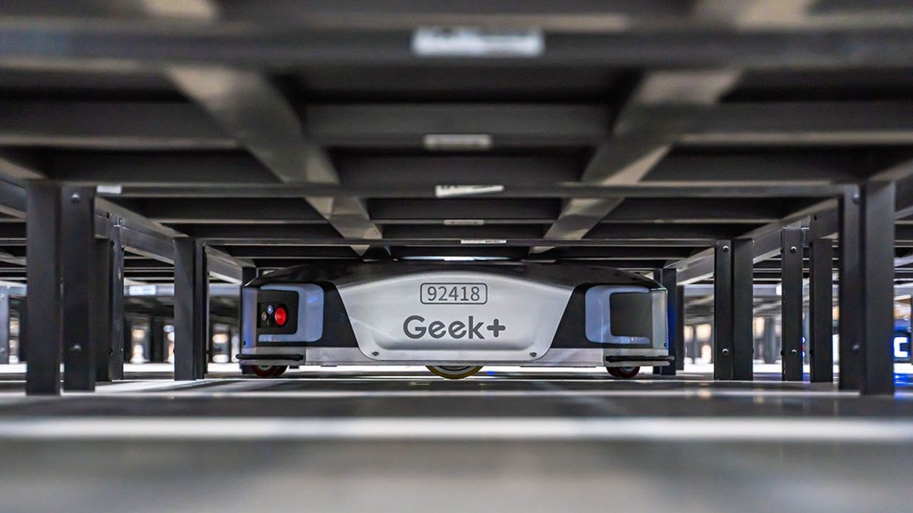 Les robots de Geek + se glissent sous des étagères pour les amener au poste des préparateurs de commandes.