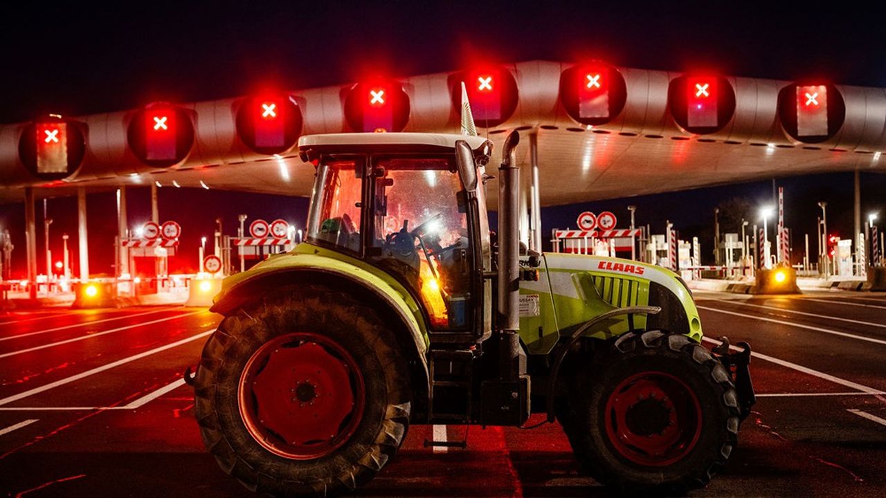 Des agriculteurs bloquent l'autoroute A10 avec des tracteurs lors d'une manifestation contre la fiscalité et la baisse des revenus, près des barrières de péage de Saint-Arnoult-en-Yvelines, au sud-ouest de Paris, le 26 janvier 2024.