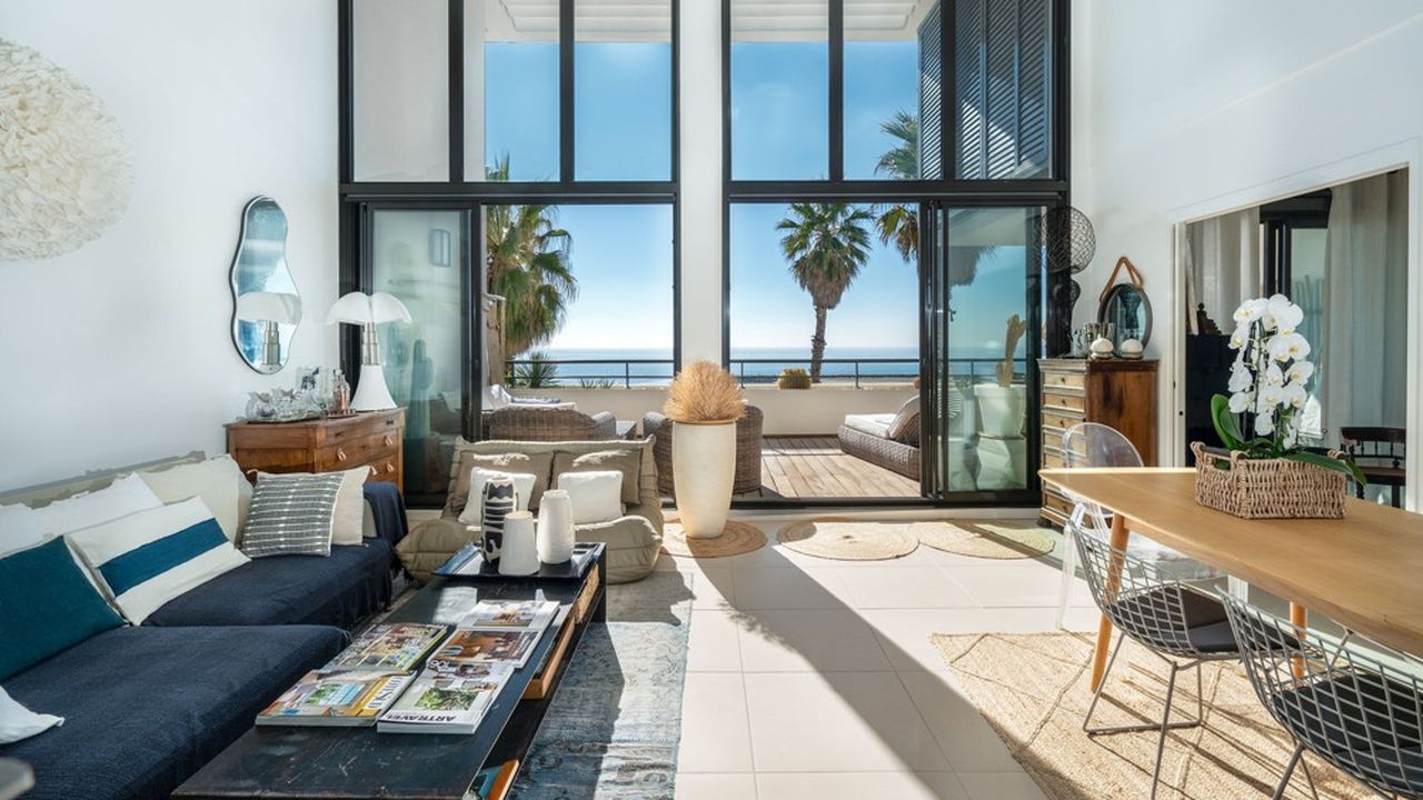 Le séjour de cet appartement donne sur une terrasse en front de mer.