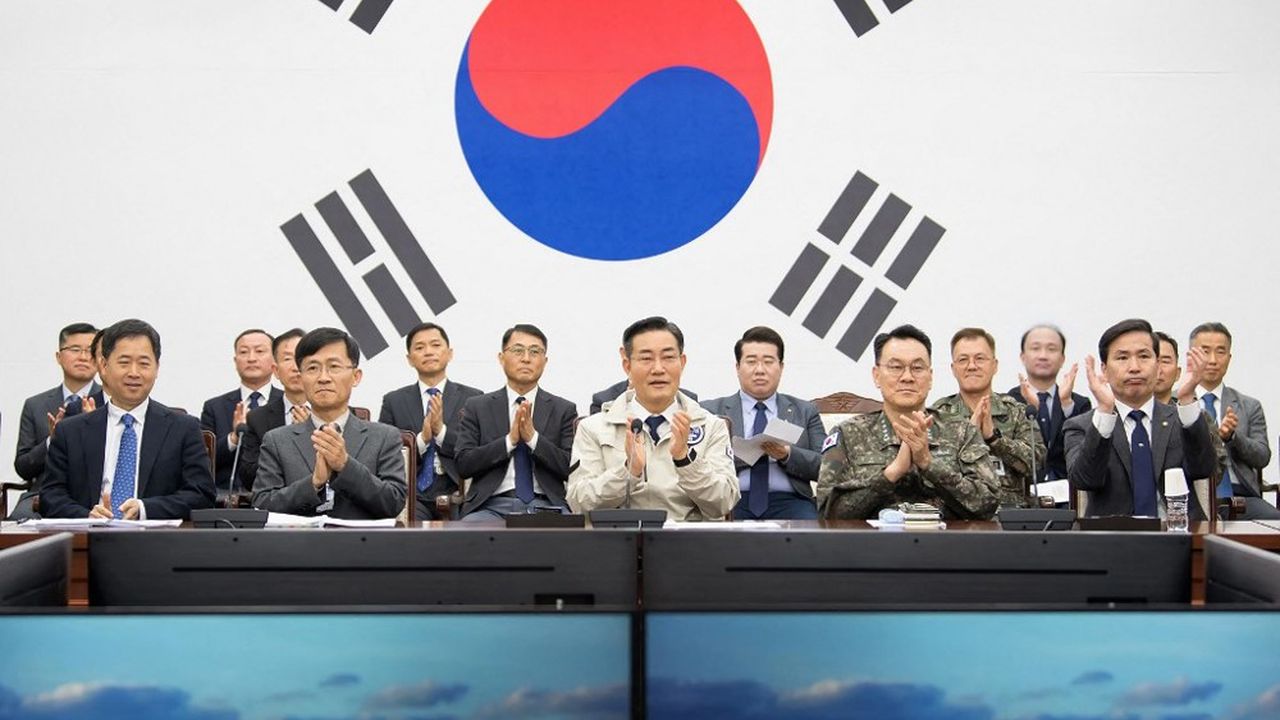 Le ministre sud-coréen de la Défense, Shin Won-sik (au centre), applaudit les officiers de son ministère, alors qu'ils regardent des moniteurs diffuser des images en direct du deuxième satellite espion sud-coréen.