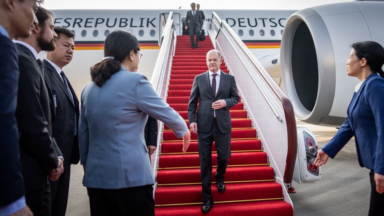 Le chancelier allemand, Olaf Scholz, descend de l'avion à l'aéroport de Chongqing, en Chine. Il est accueilli par Zhang Guozhi, le vice-maire de la ville.