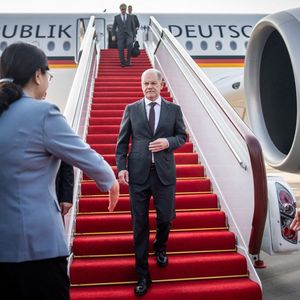 Le chancelier allemand, Olaf Scholz, descend de l'avion à l'aéroport de Chongqing, en Chine. Il est accueilli par Zhang Guozhi, le vice-maire de la ville.