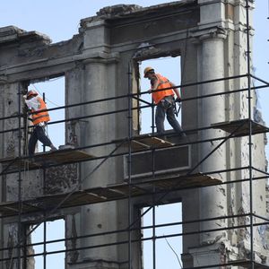 Des ouvriers du bâtiment dans un immeuble de Marioupol, en août 2023.