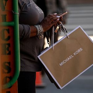 A shopper holds a Michael Kors USA Inc. shopping bag in San Francisco, California, U.S., on Thursday, June 10, 2021. Prices paid by U.S. consumers rose in May by more than forecast, extending a months-long buildup in inflation that risks becoming more established as the economy strengthens. Photographer : David Paul Morris/Bloomberg