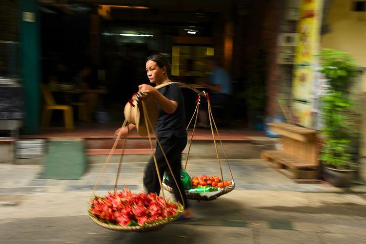 vendeuse ambulante de fruits et légumes, dans une palanche traditionnelle (đôi quang en vietnamien) / a vérifier