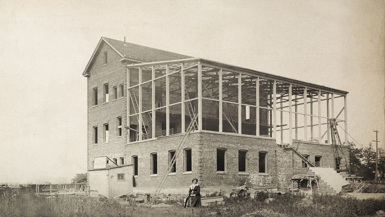 La réalisatrice française Alice Guy pose à Fort Lee, en 1912, devant le studio de sa compagnie, la Solax, en construction.