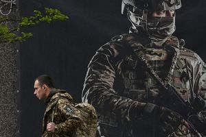 A Kiev, un militaire passe devant une affiche pour recruter des soldats.