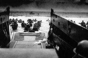Le 6 juin 1944, alors qu'ils sont sous le feu des mitrailleuses lourdes des forces de défense côtière allemandes, des soldats américains débarquent de la rampe d'une péniche de débarquement des garde-côtes américains, lors des opérations de débarquement des Alliés en Normandie.