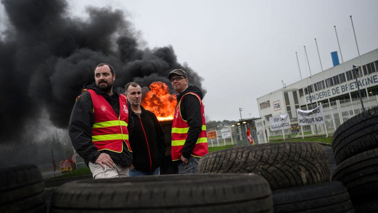 Des salariés et des syndicalistes CGT de la Fonderie de Bretagne rassemblés autour d'un feu de joie devant l'usine de Caudan, dans le Morbihan, le 18 décembre 2024.